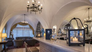 Una zona de bar con candelabro, taburetes y una vela encendida como centro de mesa.