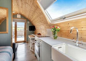 Una cucina moderna con finestra sul tetto, soffitto in legno e vista sull'esterno.