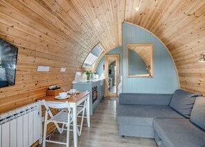 A cozy cabin interior with a dining area, kitchenette, and a living space.