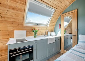 Uma cozinha compacta com claraboia, forno embutido e um pequeno espaço para refeições.