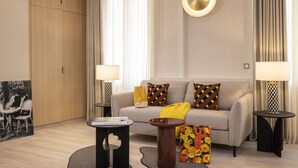 A modern living room with a sofa, two side tables, a coffee table, and a decorative pillow. - 1 bedroom apartment with private terrace - 44m2 (Paris)