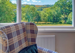 Una habitación con ventana que da a un paisaje verde.