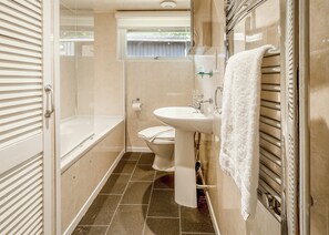 Un baño con bañera, inodoro y lavamanos.