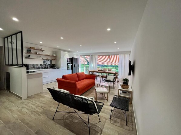 A modern apartment with a kitchen, dining area, and living room.