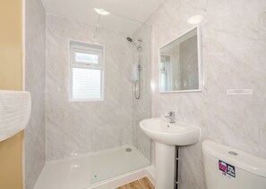 A bathroom with a shower, a sink, and a toilet.