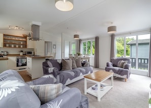 Ein modernes Wohnzimmer mit einer Couch, einem Couchtisch und einem Essbereich mit Stühlen.