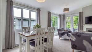 Una habitación moderna con una mesa de comedor, sillas, un sofá y un televisor.