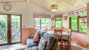 Una habitació acollidora amb un sofà, taula de dinar, cadires i un ventilador de sostre.