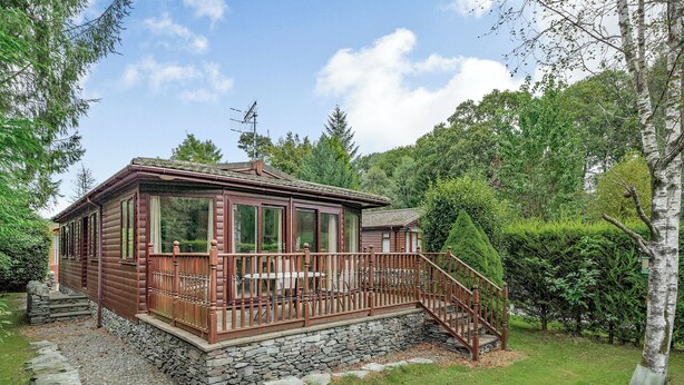 Eine Blockhütte mit Steinuntergrund, einer Holzdiele und einer Treppe zum Eingang.