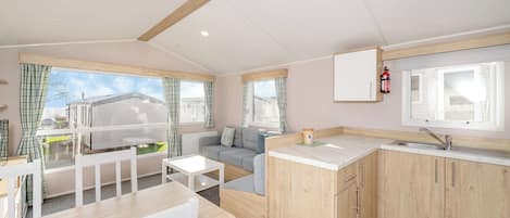 Un espacio habitable compacto con kitchenette, comedor y sofá.