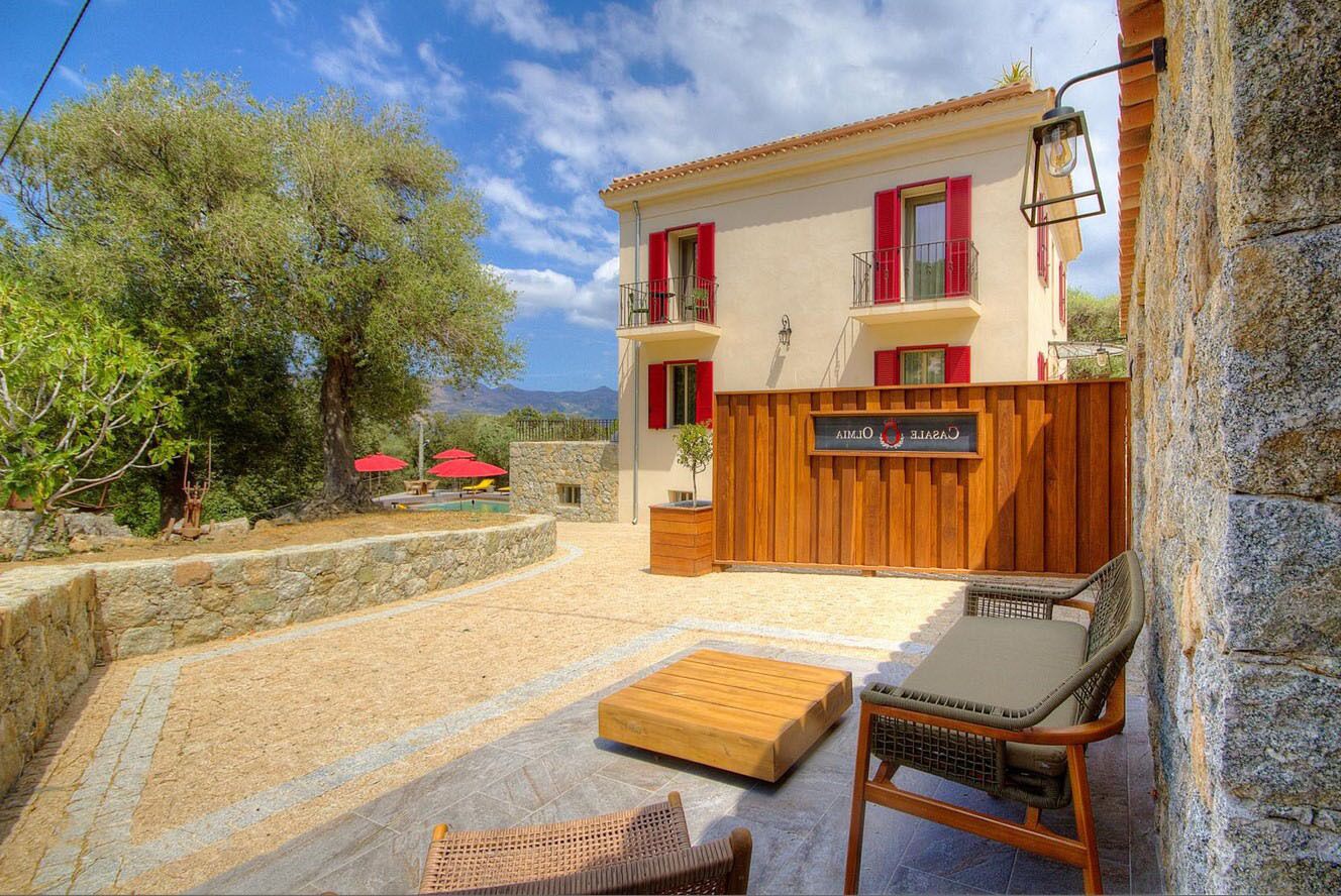 Un bâtiment à deux étages doté d’une façade en bois, d’un balcon et d’un mur en pierre.