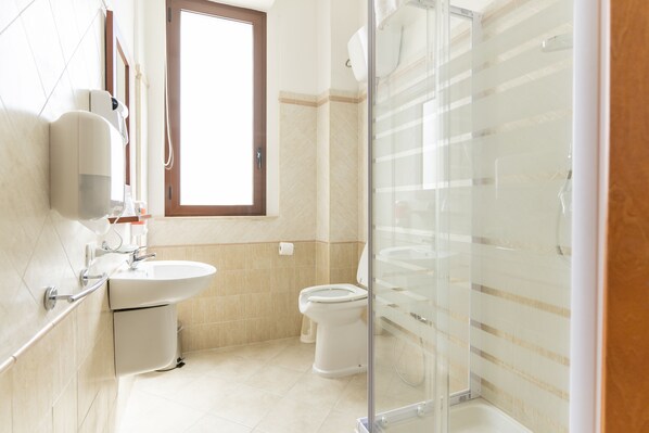 A modern bathroom with a glass shower enclosure, a sink, and a toilet. - Hotel dei Tacchi (Osini)