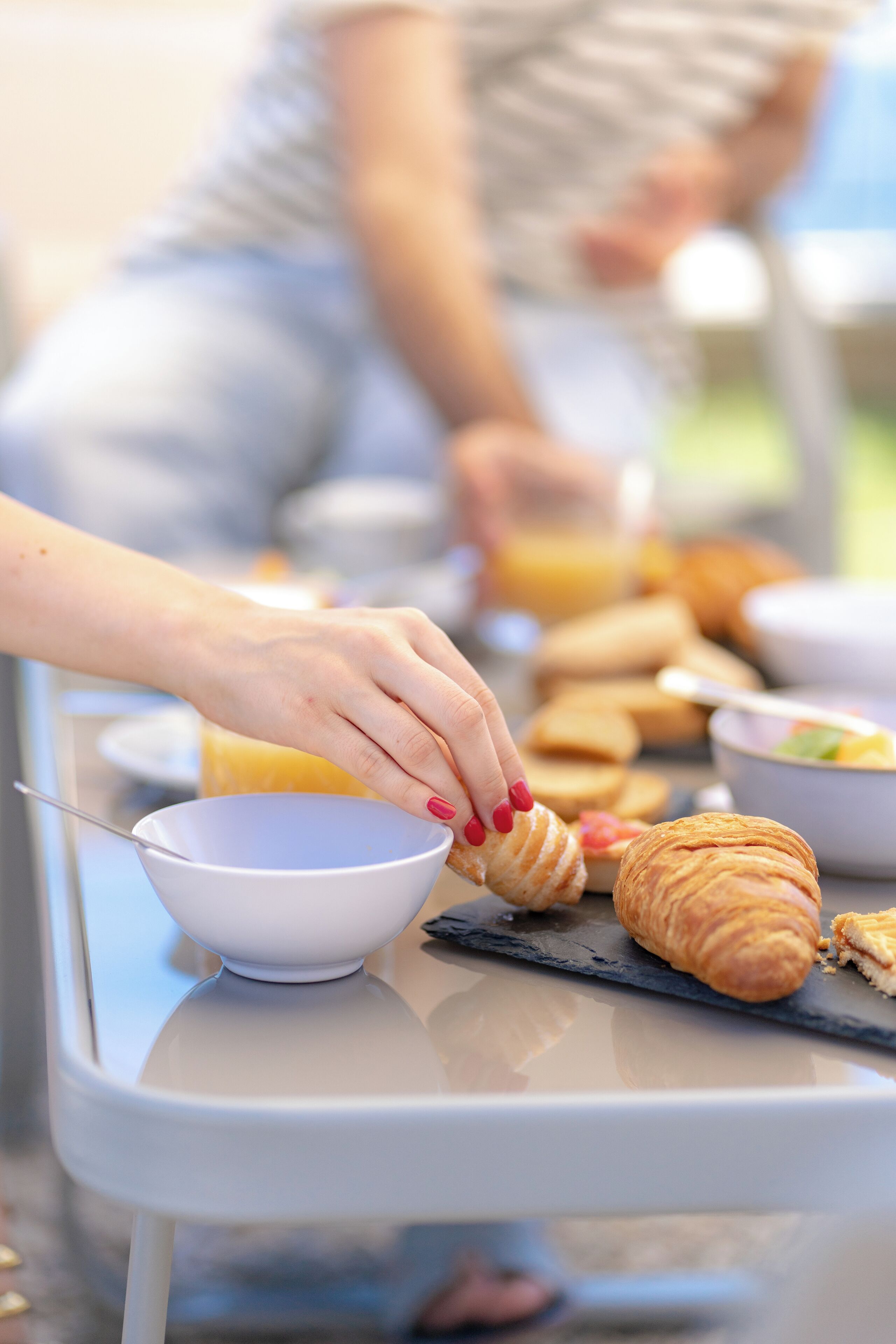 Un desayuno con croissants y un bol sobre una mesa.