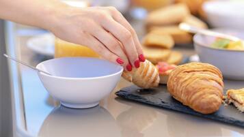 Un desayuno con croissants y un bol sobre una mesa.