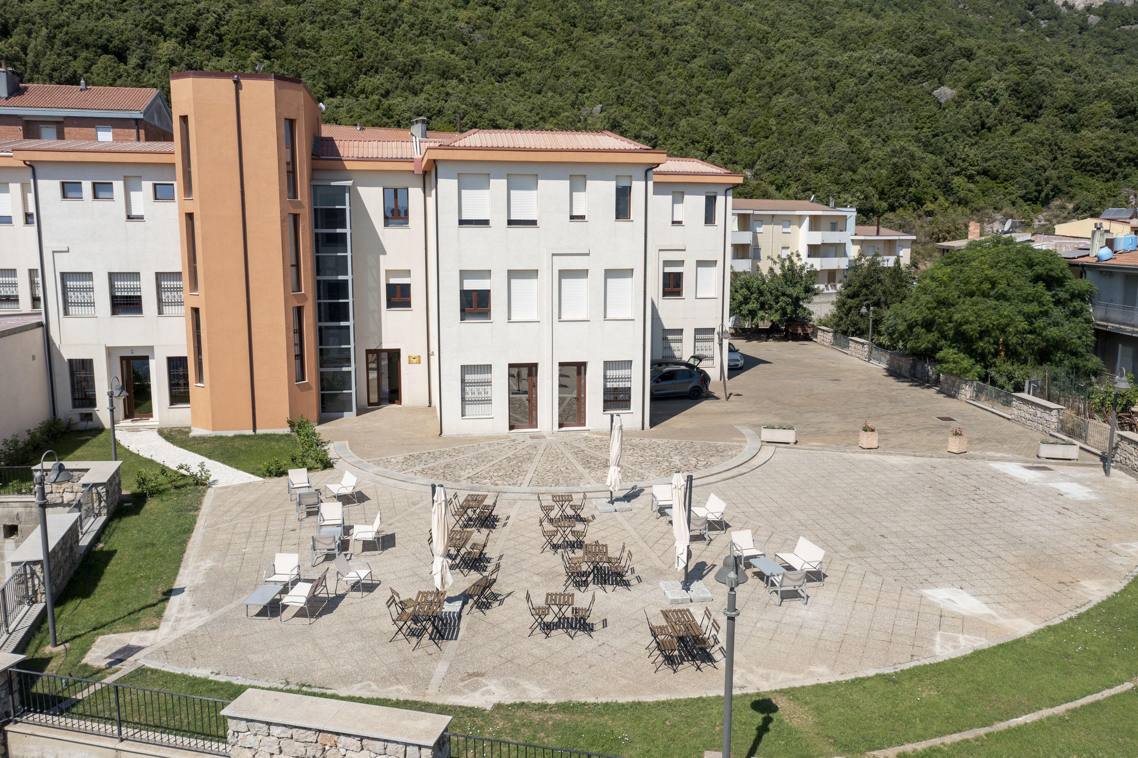 Un edificio de varios pisos con un patio central que cuenta con asientos al aire libre y una fuente.
