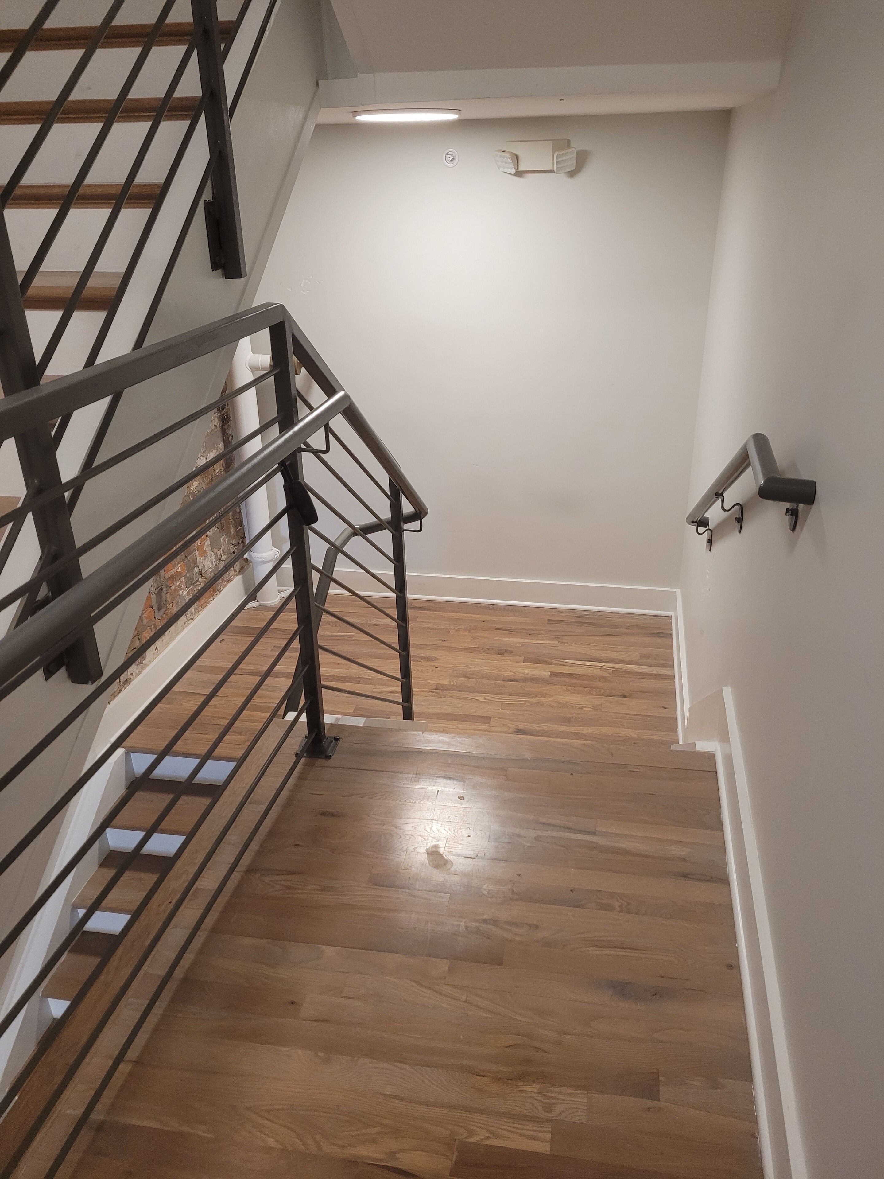 A staircase with wooden flooring and metal railings.