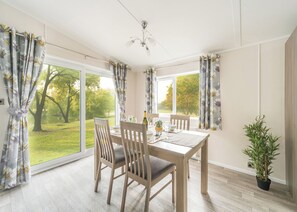 A dining area with a table, chairs, and a potted plant. - 3 bedroom accommodation in Glenluce, Newton Stewart (Glenluce, Newton Stewart)