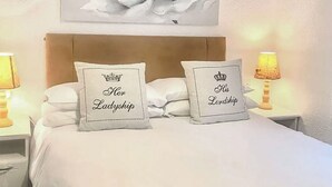Ein Bett mit zwei Kissen, jedes mit einer Krone und Text.