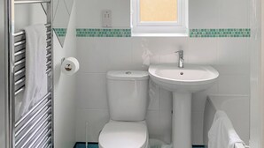 Een badkamer met toilet, wastafel en handdoekrek.
