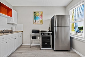Enjoy cooking in this well-equipped kitchen with a refrigerator, oven, and microwave.