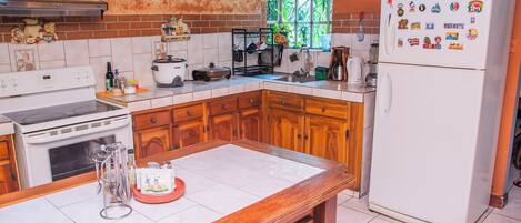 A kitchen with wooden cabinets, a white stove, and a refrigerator with magnets.