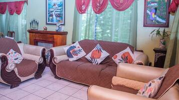 A living room with a brown sofa set, a wooden side table, and a fireplace.