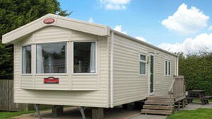 Une caravane portant l’inscription « Carnaby Ashdale », avec une porte d’entrée et un petit auvent.
