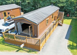 A two-story wooden cabin with a covered porch and a garage. - Outstanding holiday home offering spacious and comfortable open plan living. (Old Langho, Ribble Valley)