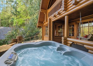 A log cabin with a hot tub and a deck area. - Timber lodge set in an elevated position with views of the lake. (Webbery, Bideford)