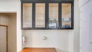 Una cucina con pensili in legno scuro sopra un baule in legno.