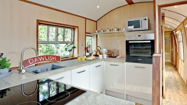 A kitchen with a built-in stove, a microwave, and a toaster. - Brunel Boutique Railway Carriage 1 (Dawlish Warren)