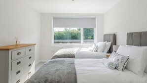 A bedroom with a bed, bedside tables, a dresser, and a window with a view of greenery. - 2 bedroom accommodation in South Molton, nr Barnstaple (South Molton, nr Barnstaple)