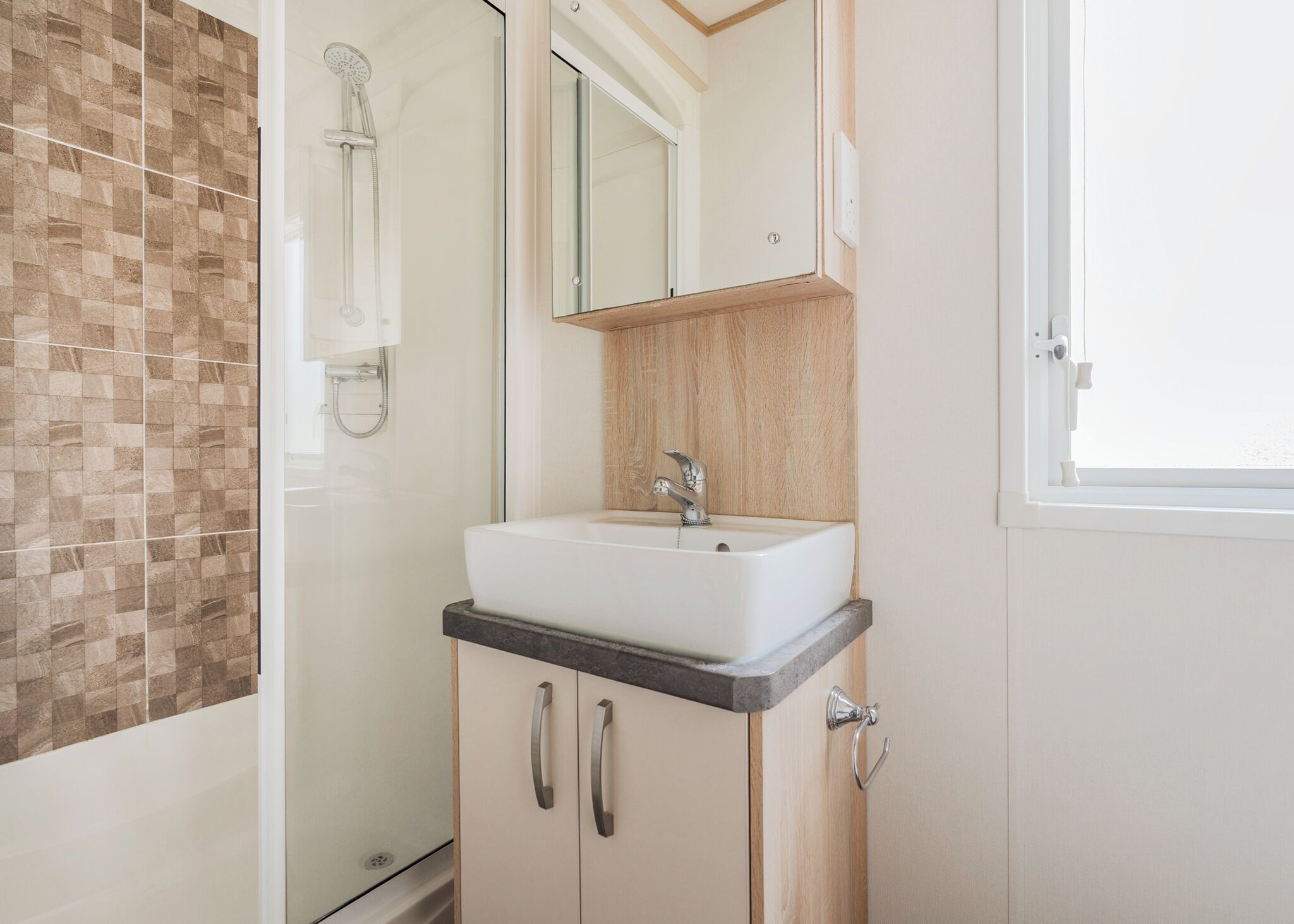 A bathroom with a shower, a sink, and a mirror.