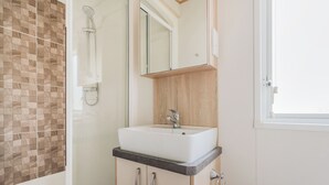 A bathroom with a shower, a sink, and a mirror.