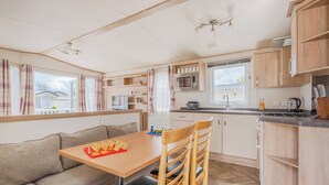 A compact kitchen with a dining area, a microwave, and a sink.