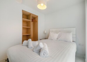 Une chambre d’hôtel avec un lit, une armoire en bois et une lampe de chevet.