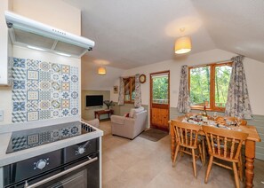 A kitchen with a stove, oven, and a dining area with a table and chairs.
