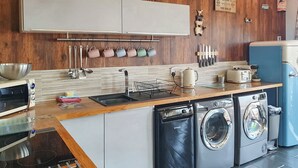 Een moderne keuken met een vaatwasser, wasmachine en een broodrooster.