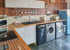 A modern kitchen with a dishwasher, washing machine, and a toaster.
