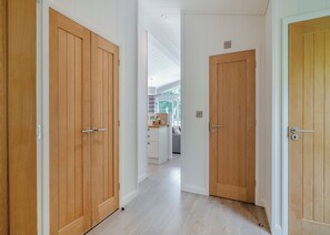 Un couloir avec des portes en bois donnant sur un espace cuisine.