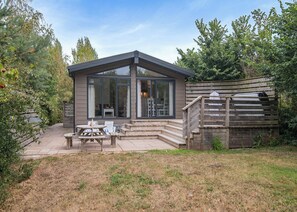 A modern house with a patio, a dining table, and chairs. - Rabbits Warren Lodge (Cannington)