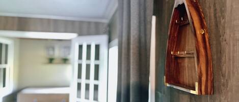 Une pièce avec un mur en bois, une petite porte en bois et une vue sur une autre pièce.