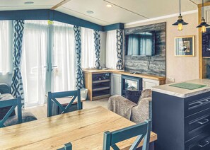 A compact kitchen with a dining area, wooden cabinets, and a built-in microwave.