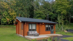 A log cabin with a patio, a small deck, and a garden area. - 1 bedroom accommodation in Annbank, Ayr (Annbank, Ayr)