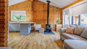 A log cabin interior with a kitchen, dining area, and a sofa. - 1 bedroom accommodation in Annbank, Ayr (Annbank, Ayr)