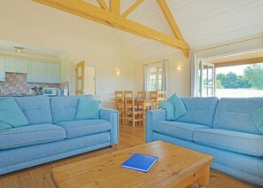 A cozy living room with two sofas, a coffee table, and a dining area with chairs and a table. - 2 bedroom accommodation in Palgrave, Diss (Palgrave, Diss)