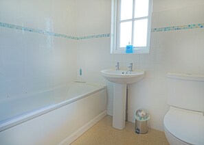 A bathroom with a bathtub, sink, and toilet. - 2 bedroom accommodation in Palgrave, Diss (Palgrave, Diss)
