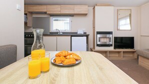 Uma cozinha compacta com fogão, forno e televisão.