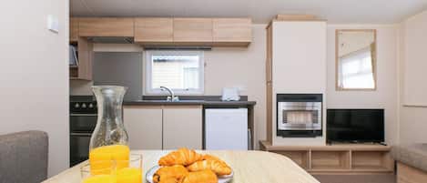 Eine Küchenzeile mit Herd, Backofen und Fernseher.