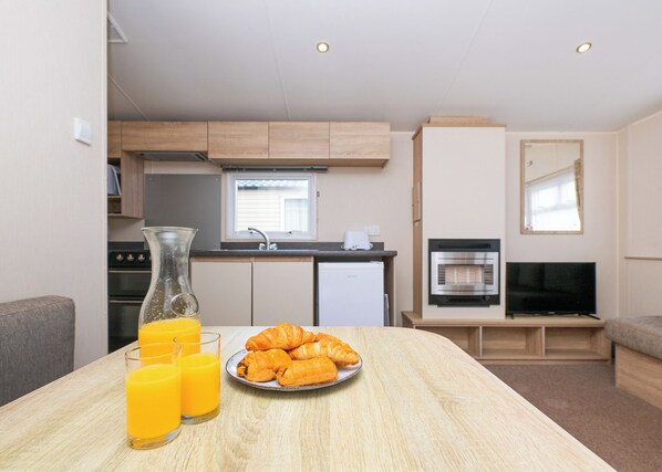 A kitchenette with a stove, oven, and a TV. - 2 bedroom accommodation in Looe (Looe)